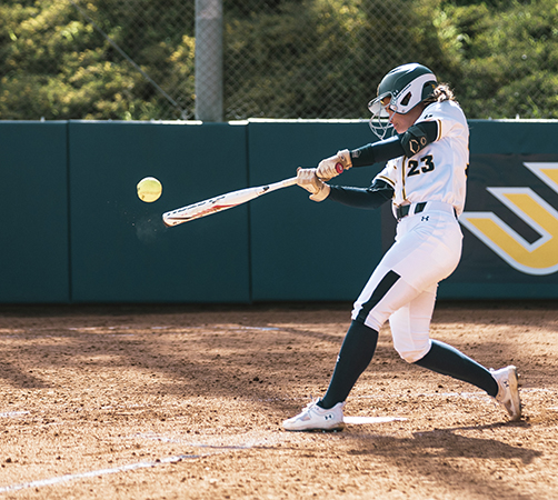 Deena swinging her bat during a game