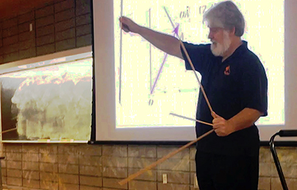 David Brown taught a lesson on vectors to the upper middle-school students on a recent Saturday. “Being a physicist I like to be visual,” he says, supplementing his slides with props to keep his young audience attentive. Photo by Melissa Miller